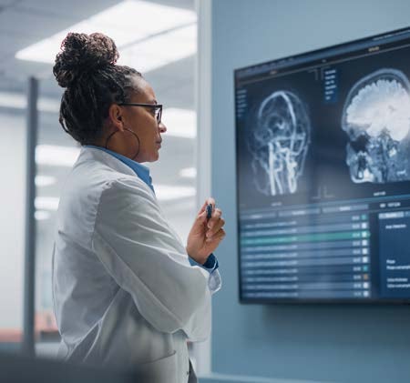 A doctor reviews brain scans on a monitor in a hospital.
