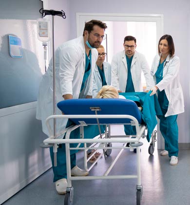 Clinicians at a hospital transport a patient in a hospital.