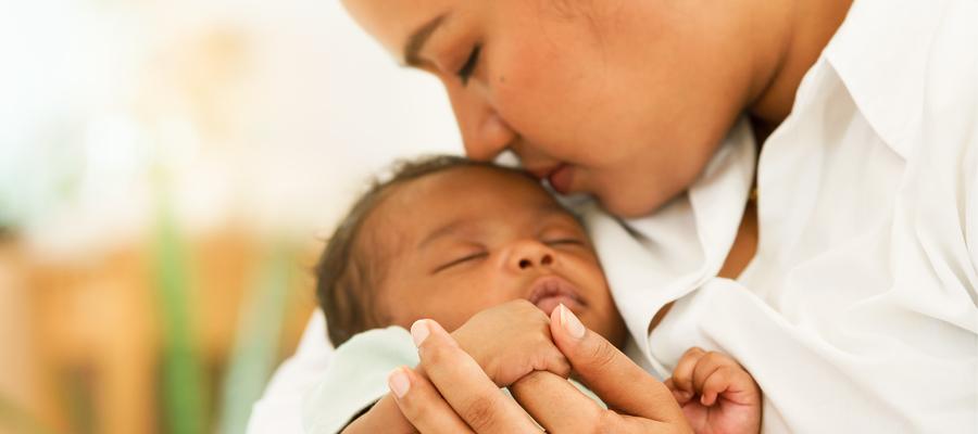 Mother holds sleeping baby.