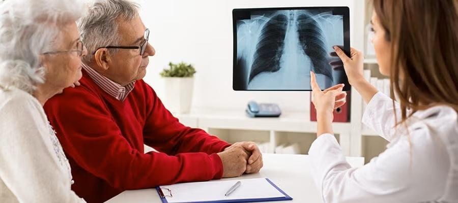 Promote Value Age Friendly. A senior couple meet with a clinician to review an x-ray image of the chest and lungs..